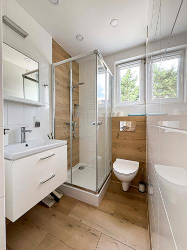a bathroom with a glass shower and a toilet at Chatka Morska in Karwia
