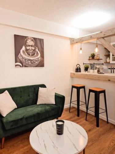 - un salon avec un canapé vert et 2 tables dans l'établissement Manaslu plein centre charmant et chaleureux, à Annecy