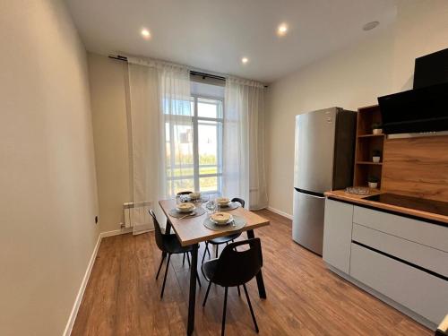a small kitchen with a table and a refrigerator at Апартаменты ЖК АТАМЕКЕН in Karagandy