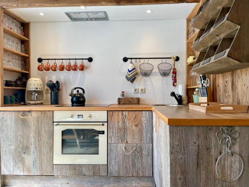 a kitchen with wooden cabinets and a stove at Weißt Du noch - Gästehäuser & Suiten in Kühlungsborn