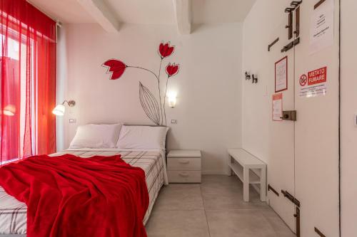 a bedroom with a bed with a red blanket on it at Suite Modena al Centro - Affitti Brevi Italia in Modena