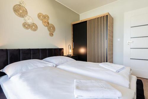 ein Schlafzimmer mit einem großen weißen Bett mit weißen Kissen in der Unterkunft VacationClub Marina Rogowo Apartament 56 in Rogowo