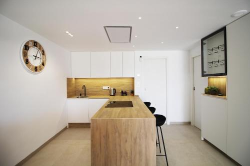 a kitchen with a counter and a clock on the wall at Three Bedroom Seaside Penthouse In Mar De Cristal in Mar de Cristal