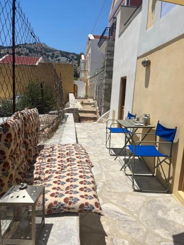 a blanket on a patio with chairs and tables at kalosymi studio, Symi in Symi
