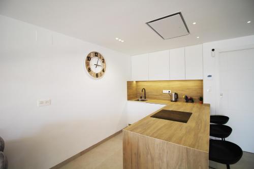 a kitchen with a counter and a clock on the wall at Three Bedroom Seaside Penthouse In Mar De Cristal in Mar de Cristal