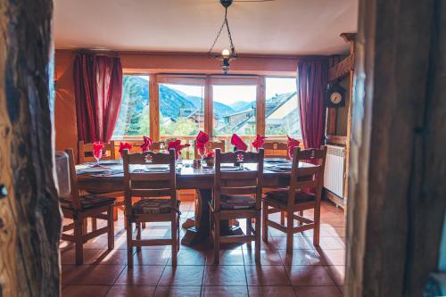 Una mesa de comedor con sillas y una gran ventana. en Les MARMOTTES, en Saint-Chaffrey
