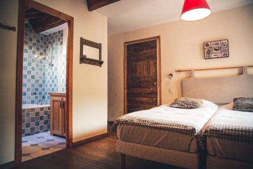 Un dormitorio con dos camas y un baño. en Les MARMOTTES, en Saint-Chaffrey