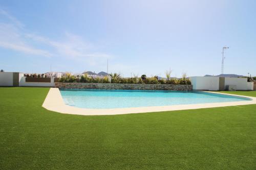 a swimming pool in a yard with green grass at Three Bedroom Seaside Penthouse In Mar De Cristal in Mar de Cristal