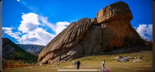 two people standing next to a large rock formation at Old City Guesthouse and Tour Ulaanbaatar Hostel in Ulaanbaatar