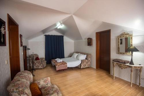 a bedroom with a bed and a couch in a room at Casa Gabriel Barbosa in Lagoa