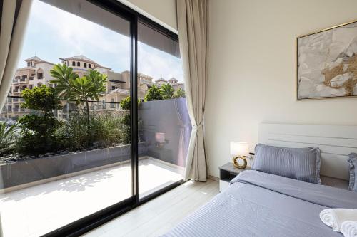a bedroom with a bed and a large window at 1-Bed in Binghatti Crescent, Next to Circle Mall in Dubai