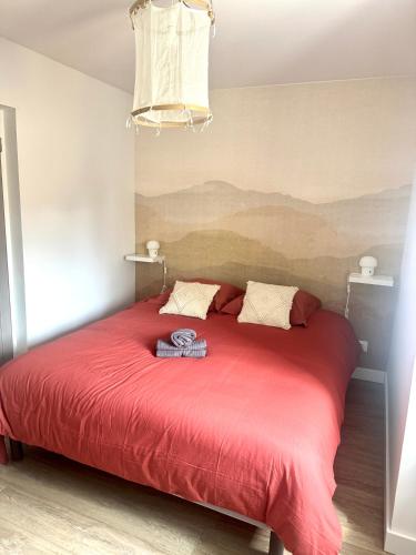 - un lit rouge avec une couverture rouge dans une chambre dans l'établissement Suite Ar Menez Du, à Châteauneuf-du-Faou