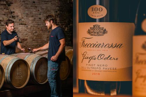 two men standing next to a large bottle of wine at La Casina in Casteggio