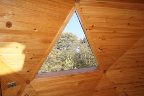 a window in the ceiling of a wooden cabin at Cabañas Domos May-Ling in Ensenada