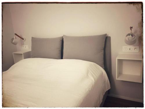 un lit avec des draps blancs et des oreillers dans une chambre dans l'établissement Suite Offenbach FSHH, à Nice