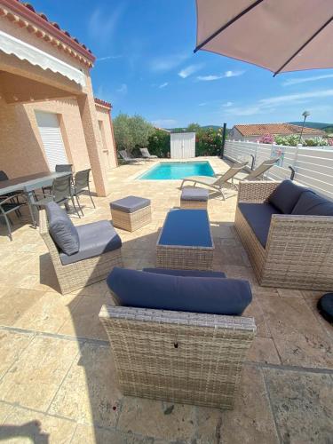 une terrasse avec mobilier en osier et une piscine dans l'établissement GITE CESAR 6p, 3ch, piscine privée, terrain privé clos, terrain de pétanque, à Vallon-Pont-dʼArc