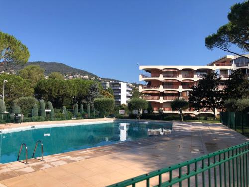 - une piscine en face d'un immeuble dans l'établissement Bel appartement en résidence avec 3 piscines, à Mandelieu-la-Napoule