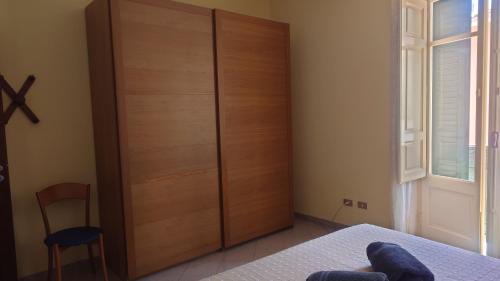 a bedroom with a large wooden closet and a bed at Casa Vacanza PIAZZA APARTMENT 1 in SantʼAndrea di Conza