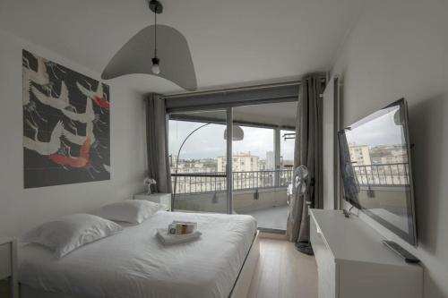 une chambre avec un lit et une grande fenêtre dans l'établissement L'Etoile, à Rennes