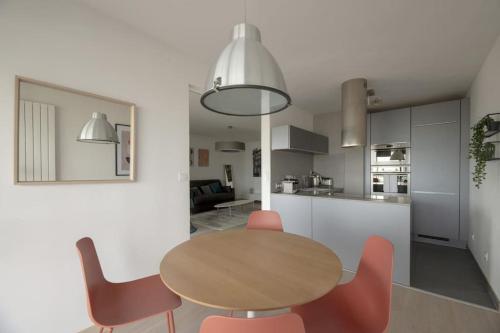 une cuisine et une salle à manger avec une table et des chaises en bois dans l'établissement L'Etoile, à Rennes