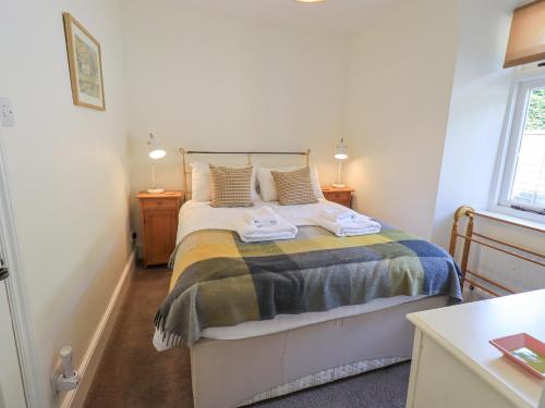 a bedroom with a bed with two towels on it at Rowan Cottage in Grasmere