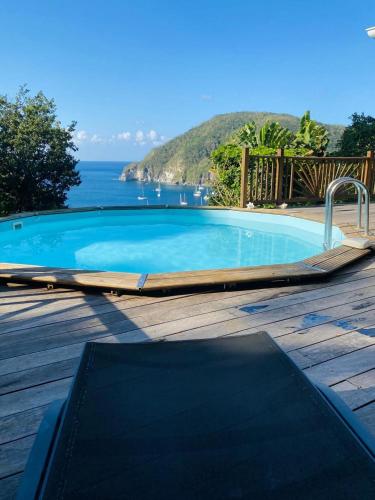 a swimming pool with a view of the ocean at Villa Palma avec vue mer et piscine privée location Domaine de la Pointe Batterie à Deshaies in Deshaies