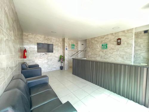a waiting room with couches and a tv at Pousada Anadia in Cajá