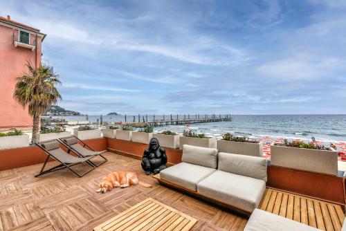 a person sitting on a balcony overlooking the beach at ReMia Suites & Leisure in Alassio