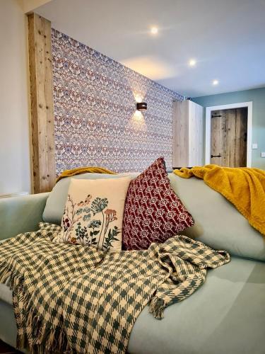 a couch with pillows and a blanket on it at Castle Mill Cottages in Wexford
