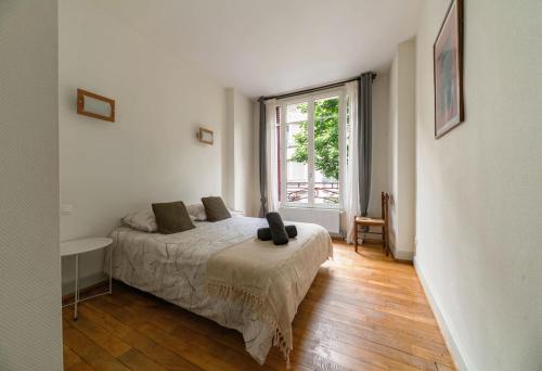 une chambre avec un lit et une grande fenêtre dans l'établissement Le Thermale - Appartement design, 2 chambres, quartier Thermes, à Vichy