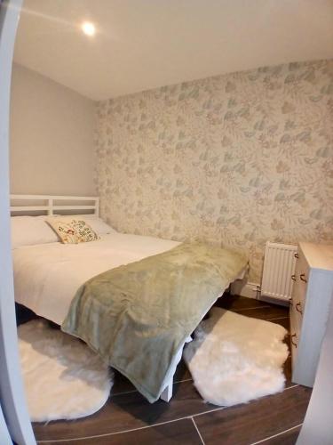 a bedroom with a bed and two rugs on the floor at Castle Mill Cottages in Wexford