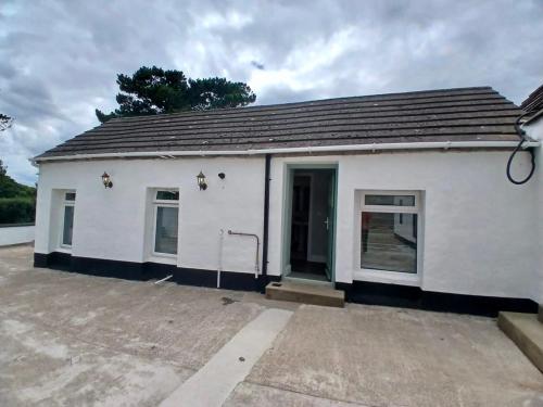 a small white building with a parking lot at Castle Mill Cottages in Wexford