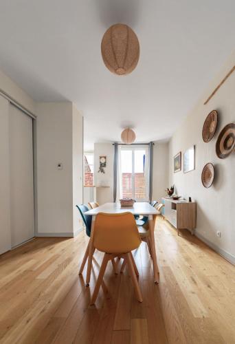 une salle à manger et un salon avec une table et des chaises dans l'établissement Le Thermale - Appartement design, 2 chambres, quartier Thermes, à Vichy