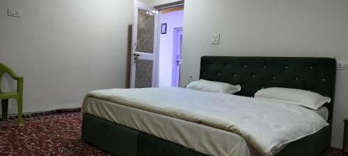 a bedroom with a large bed with a black headboard at Elizabeth paying guest house Tangmarg gulmarg in Gulmarg