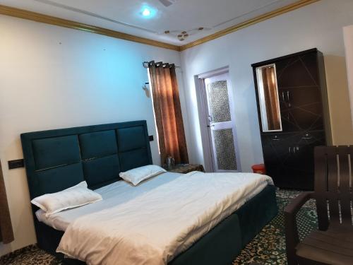 a bedroom with a large bed and a window at Elizabeth paying guest house Tangmarg gulmarg in Gulmarg