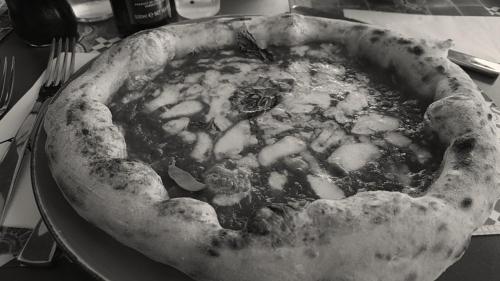 a pizza sitting on a plate on a table at Casa Vacanza PIAZZA APARTMENT 1 in SantʼAndrea di Conza