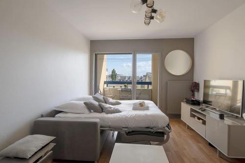 une chambre avec un grand lit et une télévision dans l'établissement Le Mail à Rennes, à Rennes