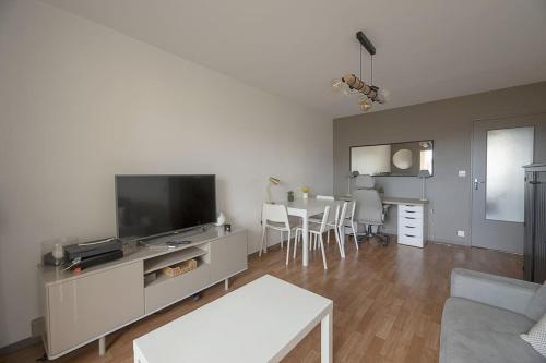 un salon avec une télévision et une table dans l'établissement Le Mail à Rennes, à Rennes