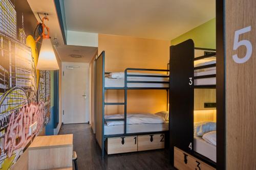 a room with three bunk beds and a desk at Generator Berlin Alexanderplatz in Berlin