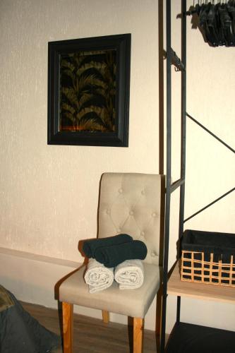 a room with a chair with towels on it at Appartement ELYNE Quartier des Templiers à 400m de la mer in Saint-Raphaël