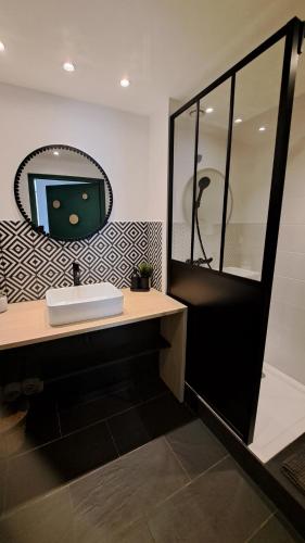 a bathroom with a sink and a mirror at Les Appartements du 104 in Saint-Jean-de-Monts