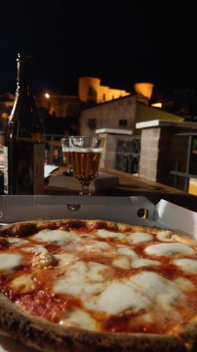 a pizza sitting on a table with a glass of wine at Casa Vacanza PIAZZA APARTMENT 1 in SantʼAndrea di Conza