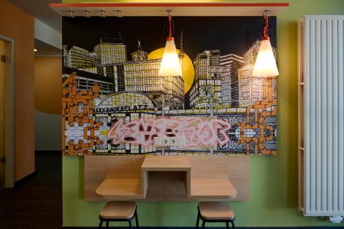 a wall with a painting of a city at Generator Berlin Alexanderplatz in Berlin