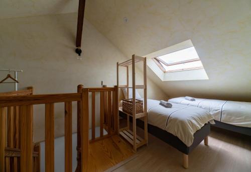 - une petite chambre avec un lit et une lucarne dans l'établissement Le Grenet - Appartement design en duplex, à Vichy