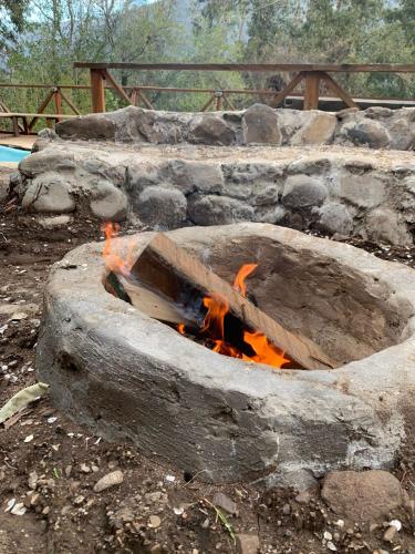 a fire burns in a stone fire pit at Cabaña Nido de Almas in San José de Maipo