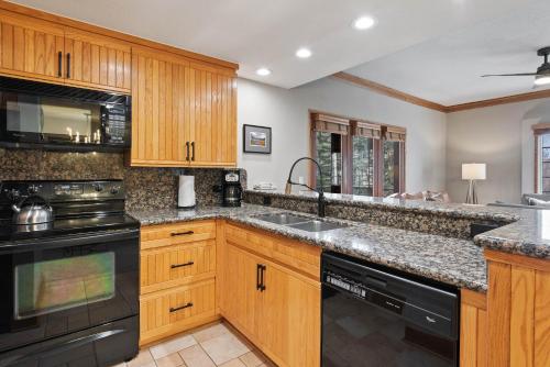 a kitchen with wooden cabinets and black appliances at The Charter at Beaver Creek C020 in Beaver Creek