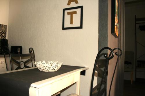 a dining room table with a white bowl on top of it at Appartement ELYNE Quartier des Templiers à 400m de la mer in Saint-Raphaël