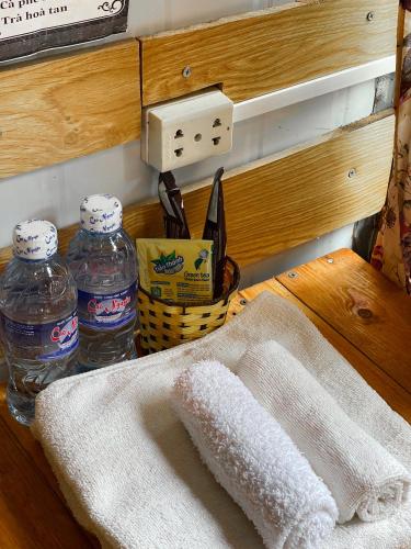 a table with two bottles of water and a towel at Homestay Gấu Smile - Mộc Châu in Sơn La