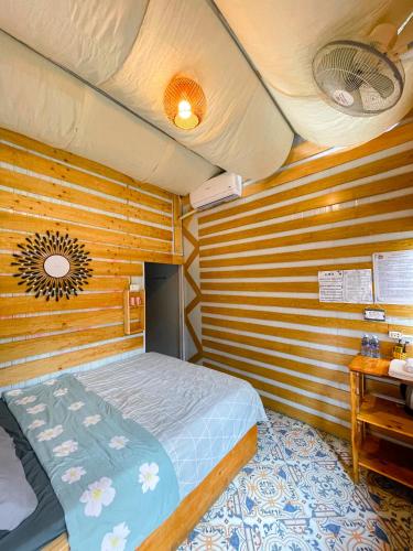 a bedroom with a bed in a wooden room at Homestay Gấu Smile - Mộc Châu in Sơn La