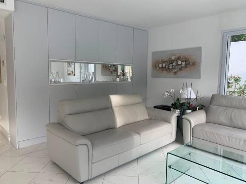 un salon avec deux canapés et une table en verre dans l'établissement Cannes centre Villa piscine spa, à Cannes